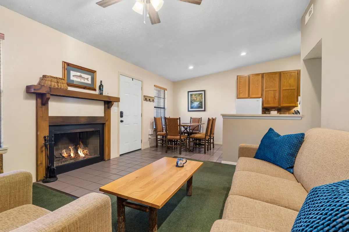 A comfortable living area with a cozy sofa positioned near a fireplace and a dining table. The space is perfect for gatherings and doubles as a place for extra guests to sleep, thanks to the sofa sleeper.